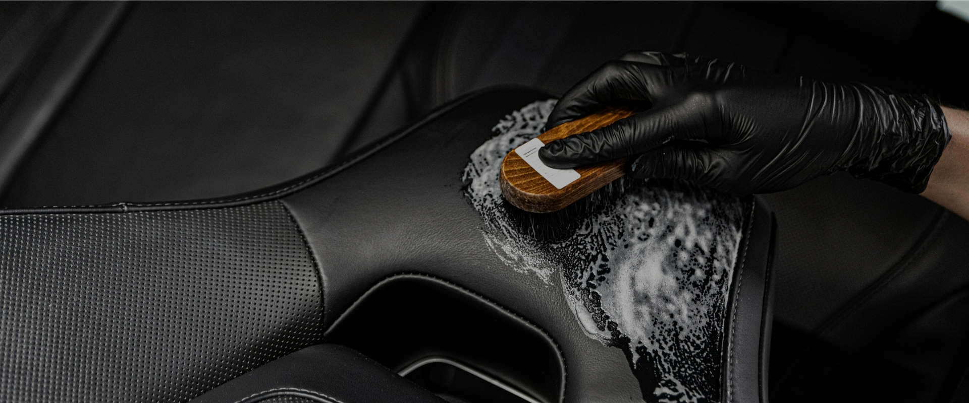 Czyszczenie elementów tapicerki przy użyciu pieniącej się chemii i szczotki.